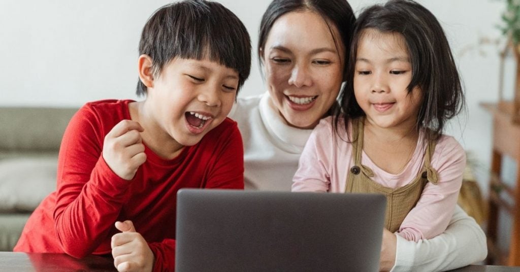 mother and her two kids smiling and laughing on a video call